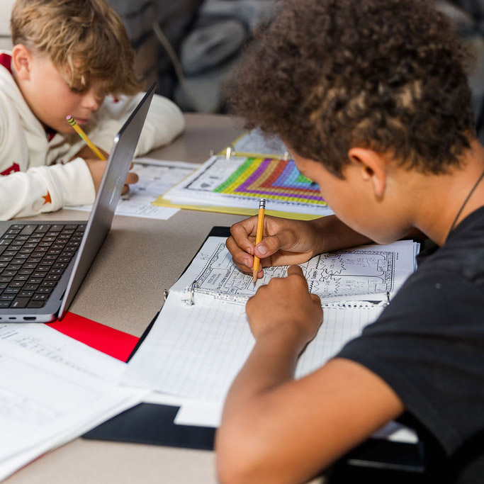 Students working on classwork in the common area