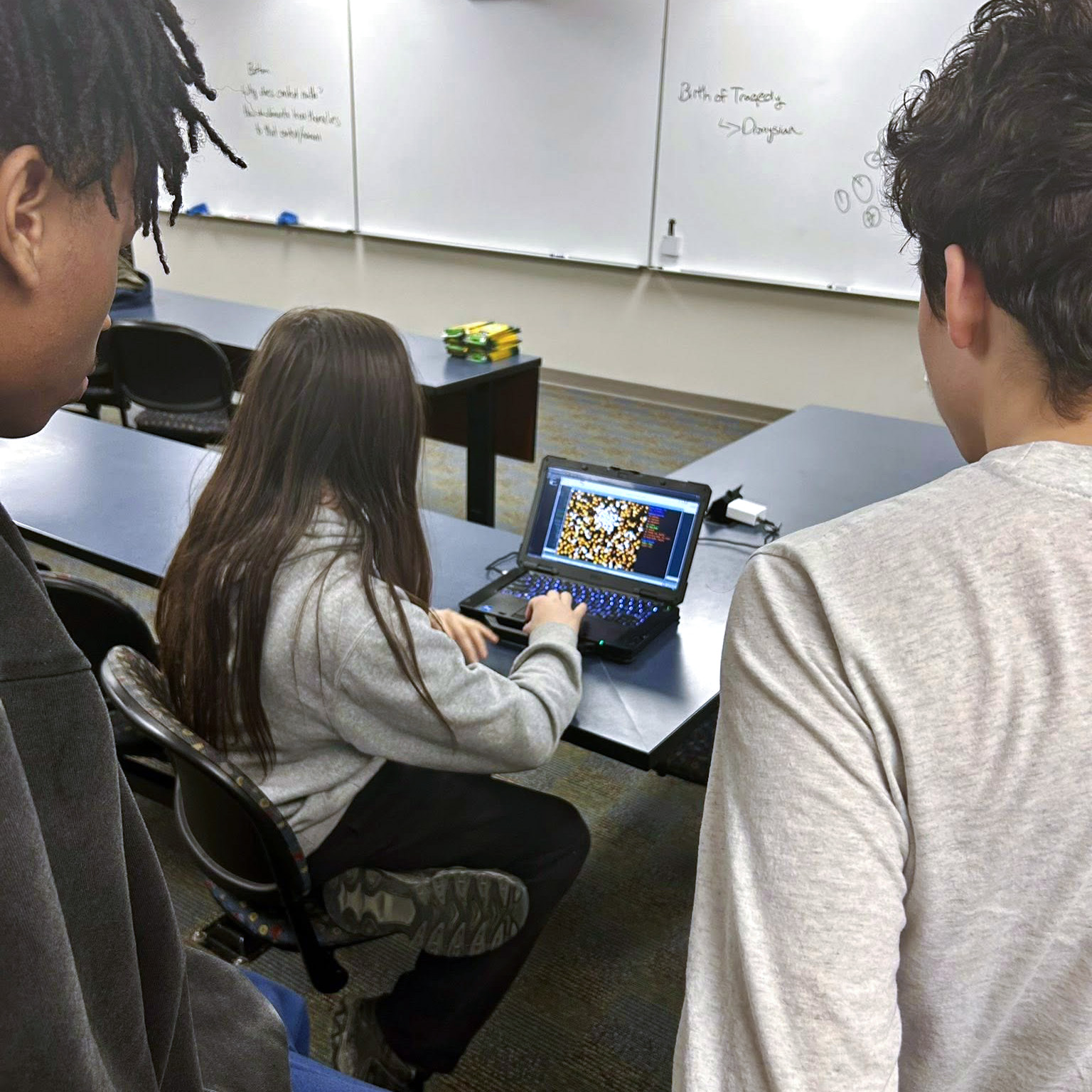 Three high school students collaborating on a project
