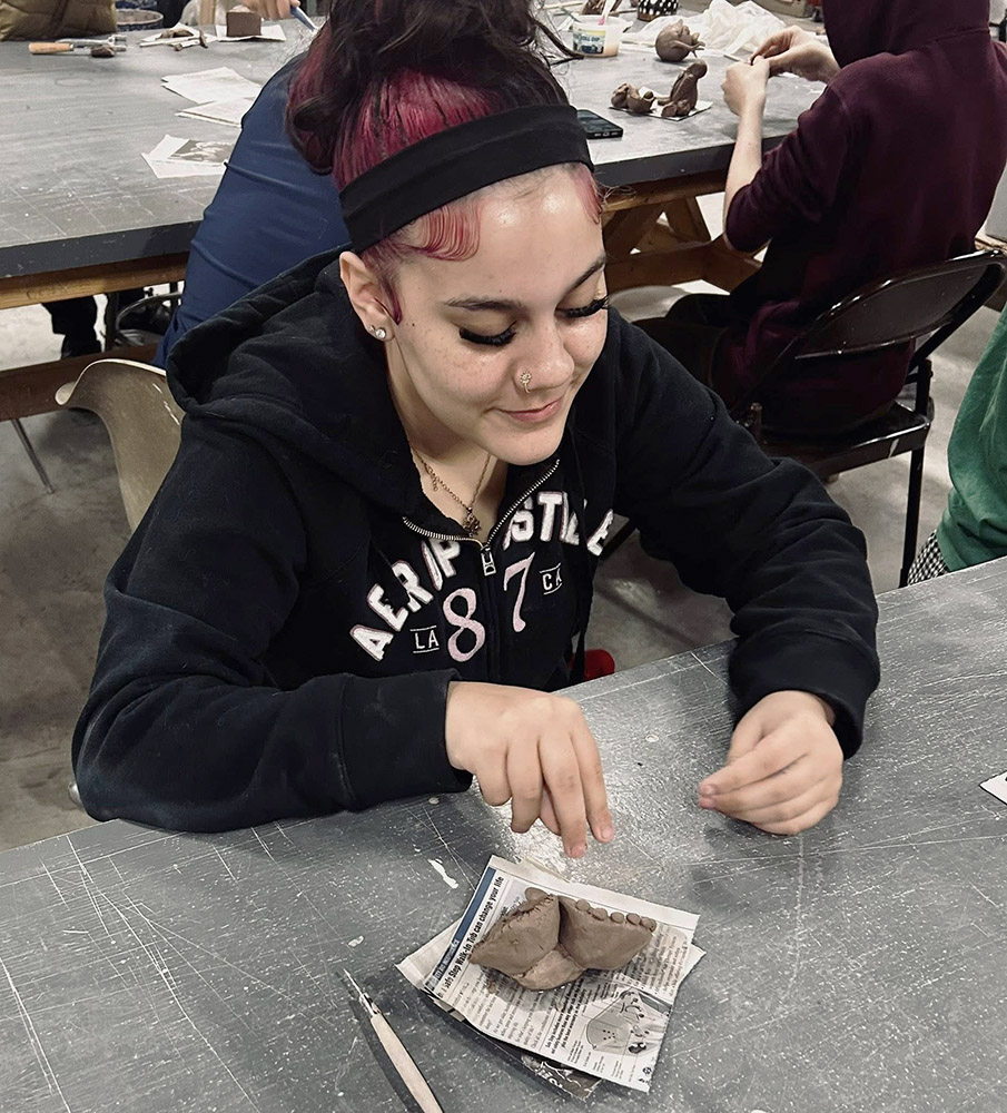 High school student working with clay during a special art class