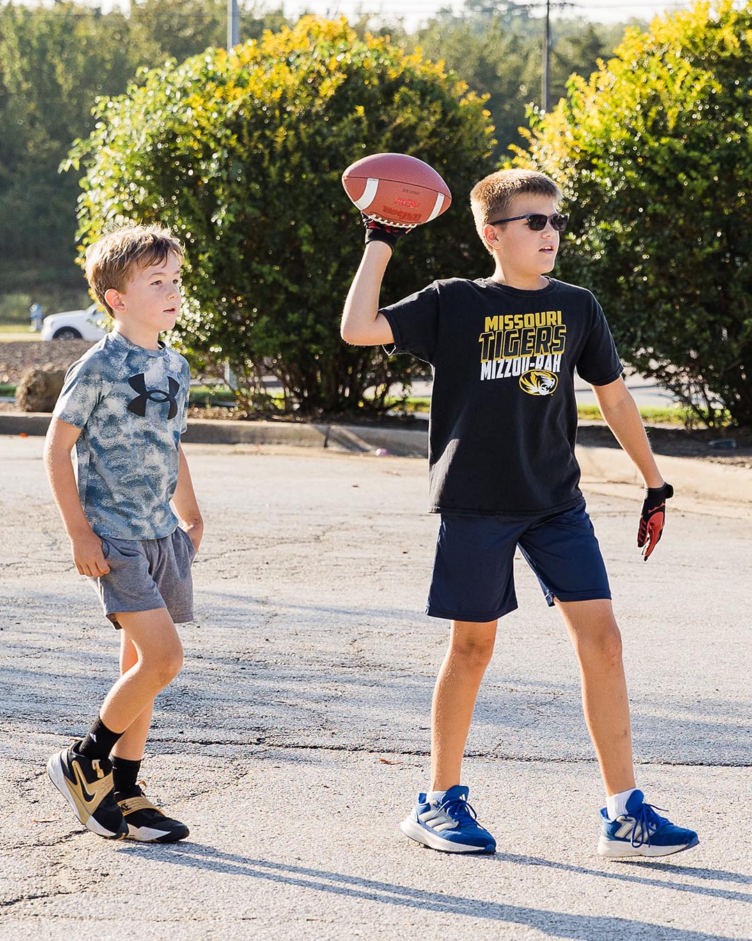 Two middle school kids at recess, one throwing a football