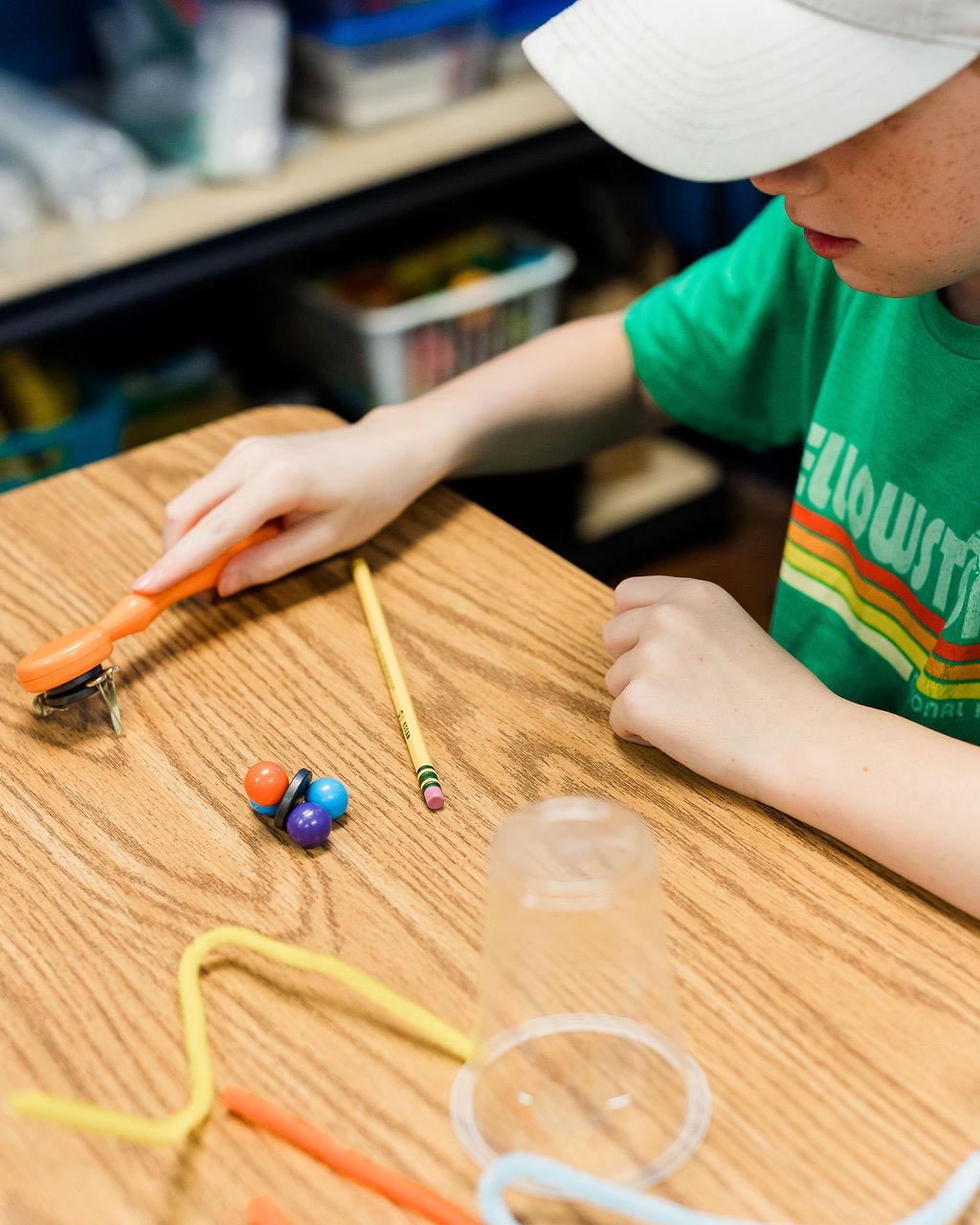 Student playing with magnets and pipe cleaners
