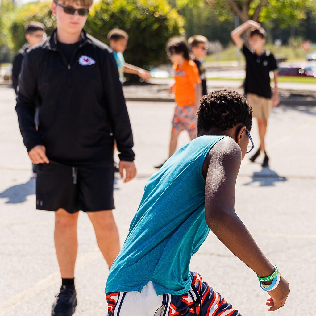 Middle school students playing basketball outside during recess